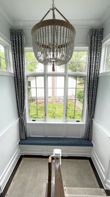 Shirred Drapery Side Panels in a High Window and Upholstered Box Border Window Seat Cushion in a Stairway Landing