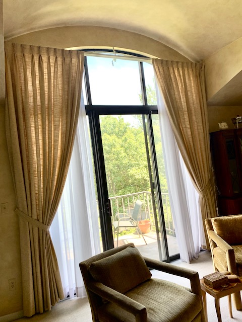 Pinch Pleat Draperies with Tie Backs, Sheers Underneath in an Arched Window in Living Room