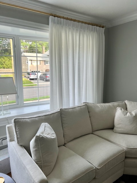 White Linen Pleated Draperies on a TRAX Gold Rod in an Updated Living Room
